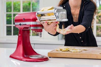 Žena krájí těstovinové těsto s kuchyňským robotem KitchenAid