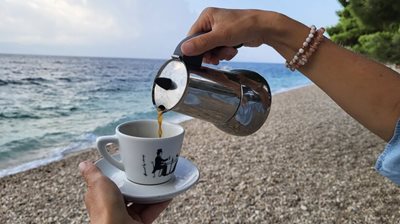 Nalévání kávy z moka konvičky u moře