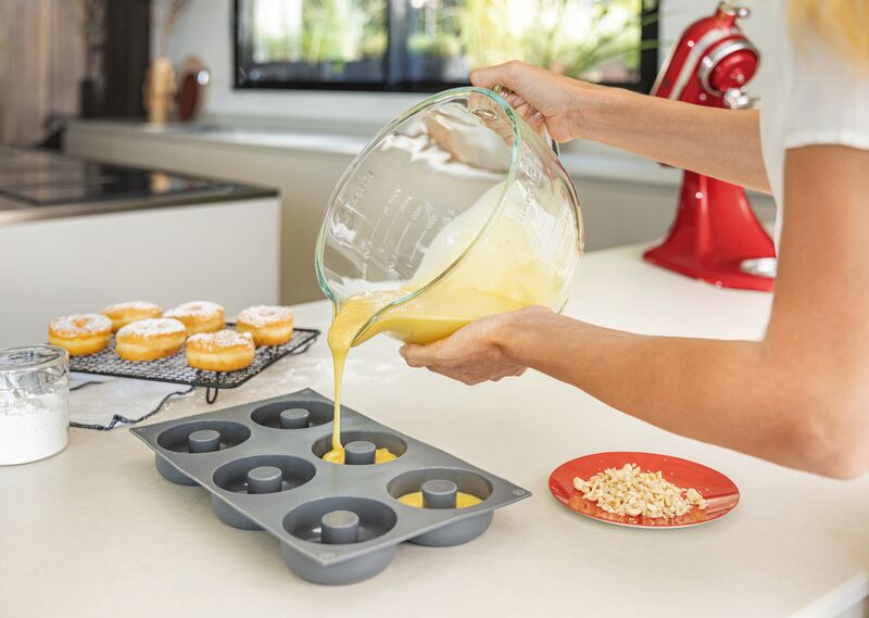 Žena nalévá těsto do formy ze skleněné mísy KitchenAid