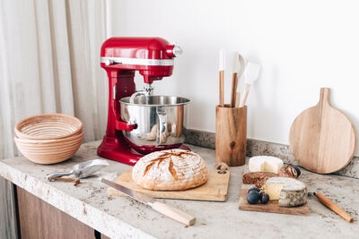 Kuchyňské doplňky a robot KitchenAid na kuchyňské lince.